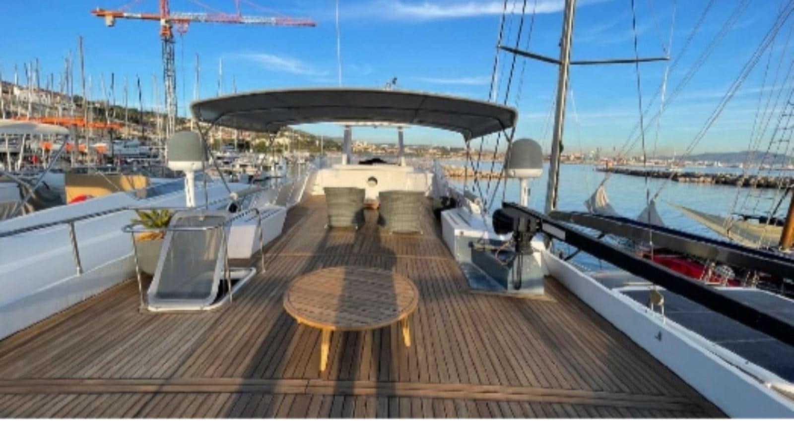 a deck with a table and chairs on it aboard SEA SEVEN Yacht for Sale