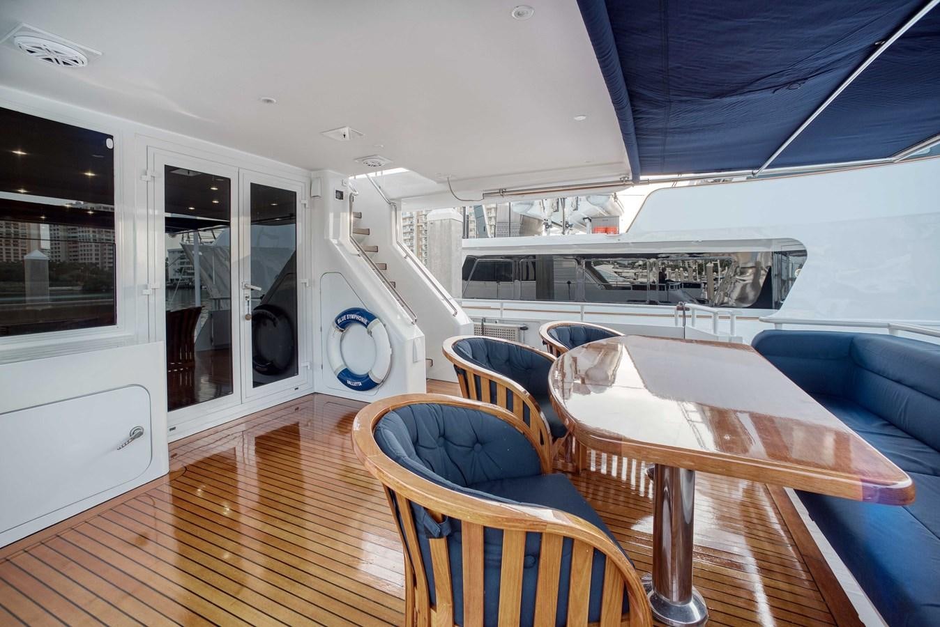 a boat with a table and chairs aboard BLUE SYMPHONIE Yacht for Sale