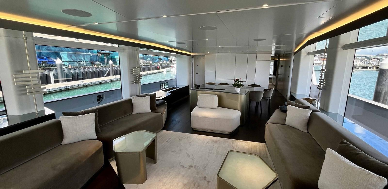 a room with a large window and a table with chairs and a large window with a view of aboard DB Yacht for Sale