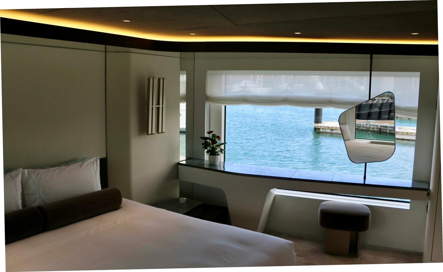 a room with a bed and a large window aboard DB Yacht for Sale
