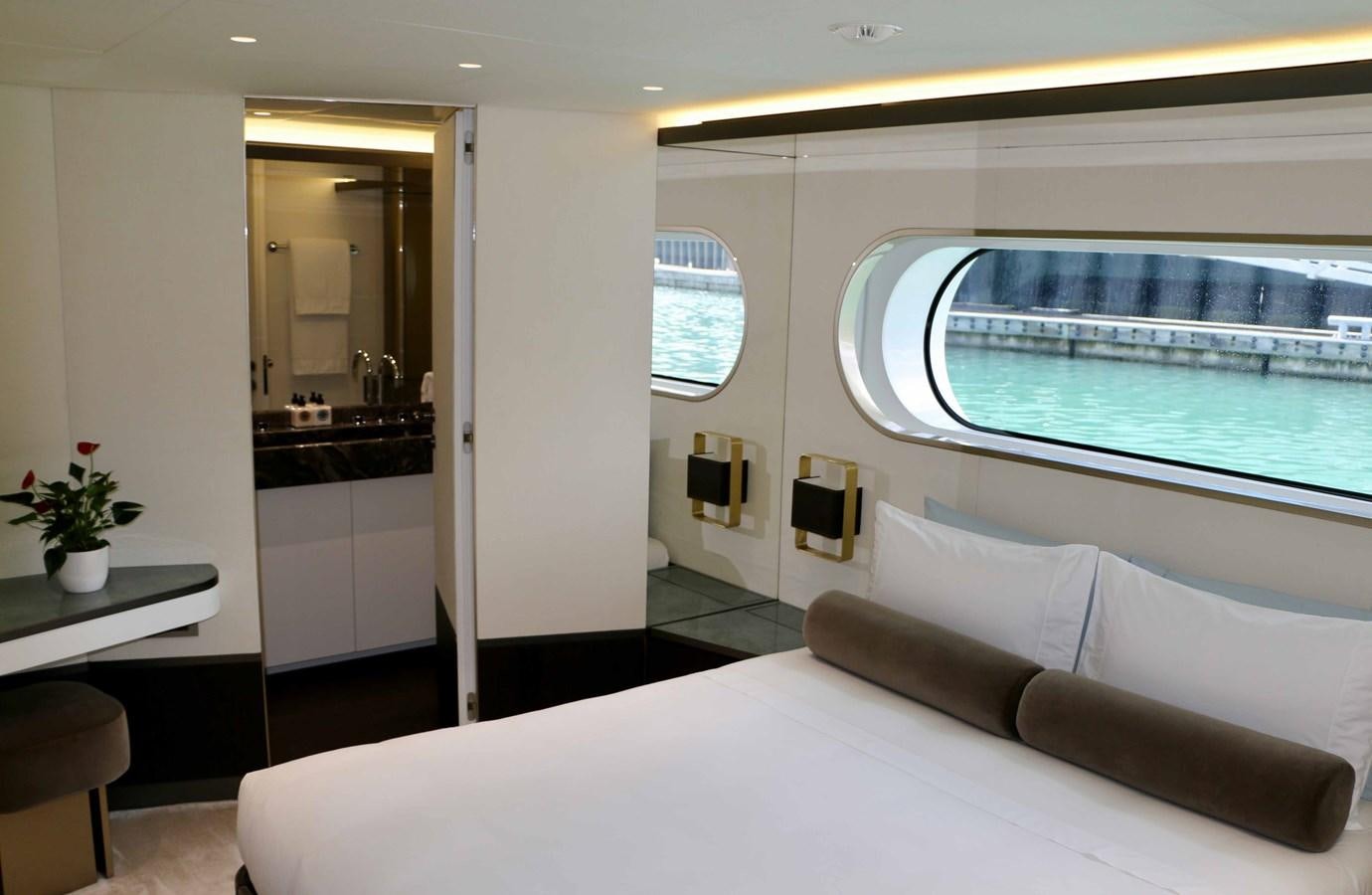 a room with a large window and a table with chairs and a large pool aboard DB Yacht for Sale