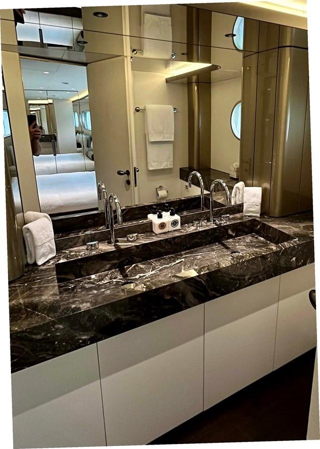 a bathroom with a countertop sink and a large mirror aboard DB Yacht for Sale