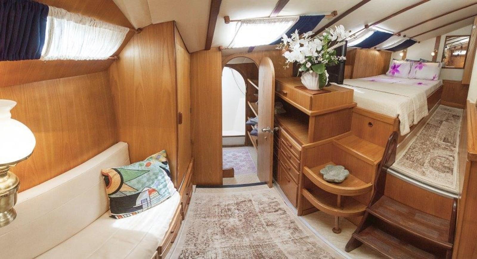 a room with a bed and a chair aboard CONAN Yacht for Sale