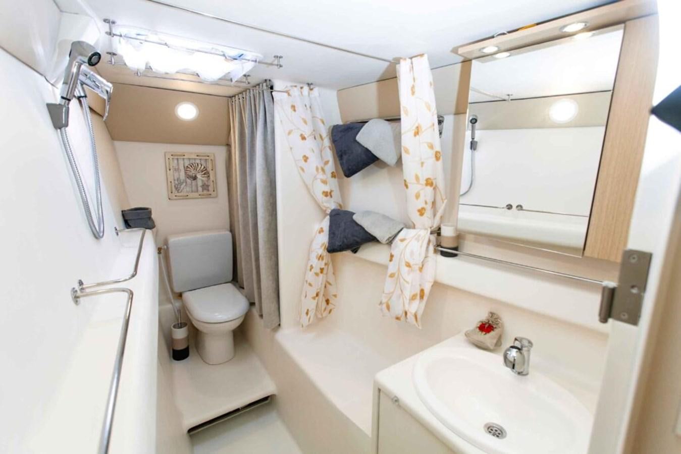 a bathroom with a toilet sink and a bathtub aboard CONAN Yacht for Sale