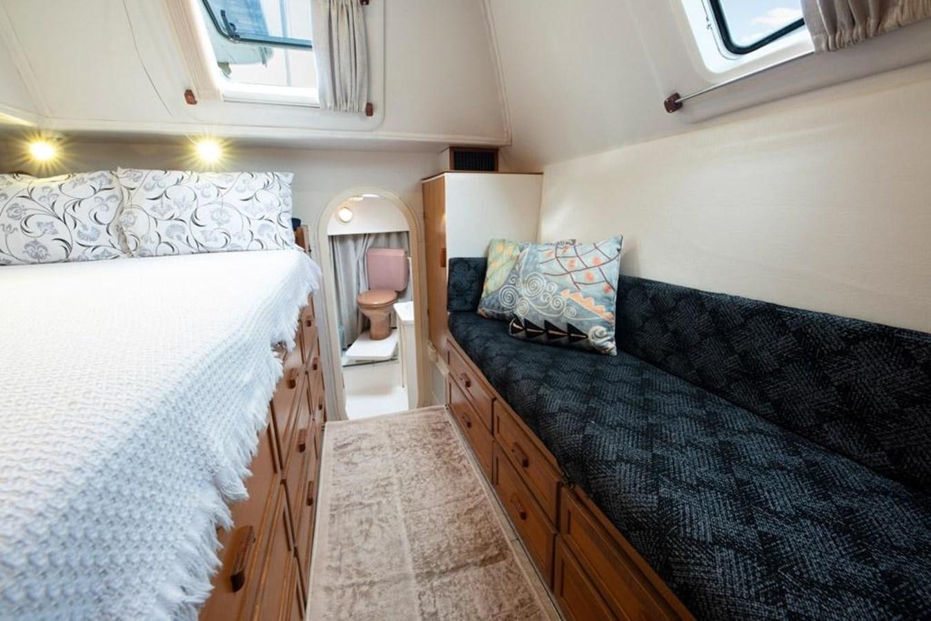 a bedroom with a bed and a couch aboard CONAN Yacht for Sale