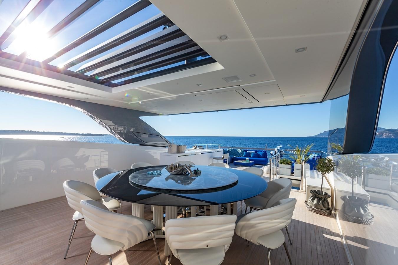 a large room with a table and chairs and a large blue pool aboard SL118 #653 Yacht for Sale