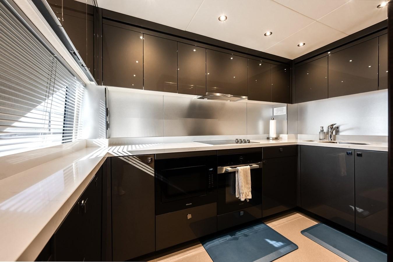 a kitchen with black cabinets aboard TRIGGER HAPPY Yacht for Sale