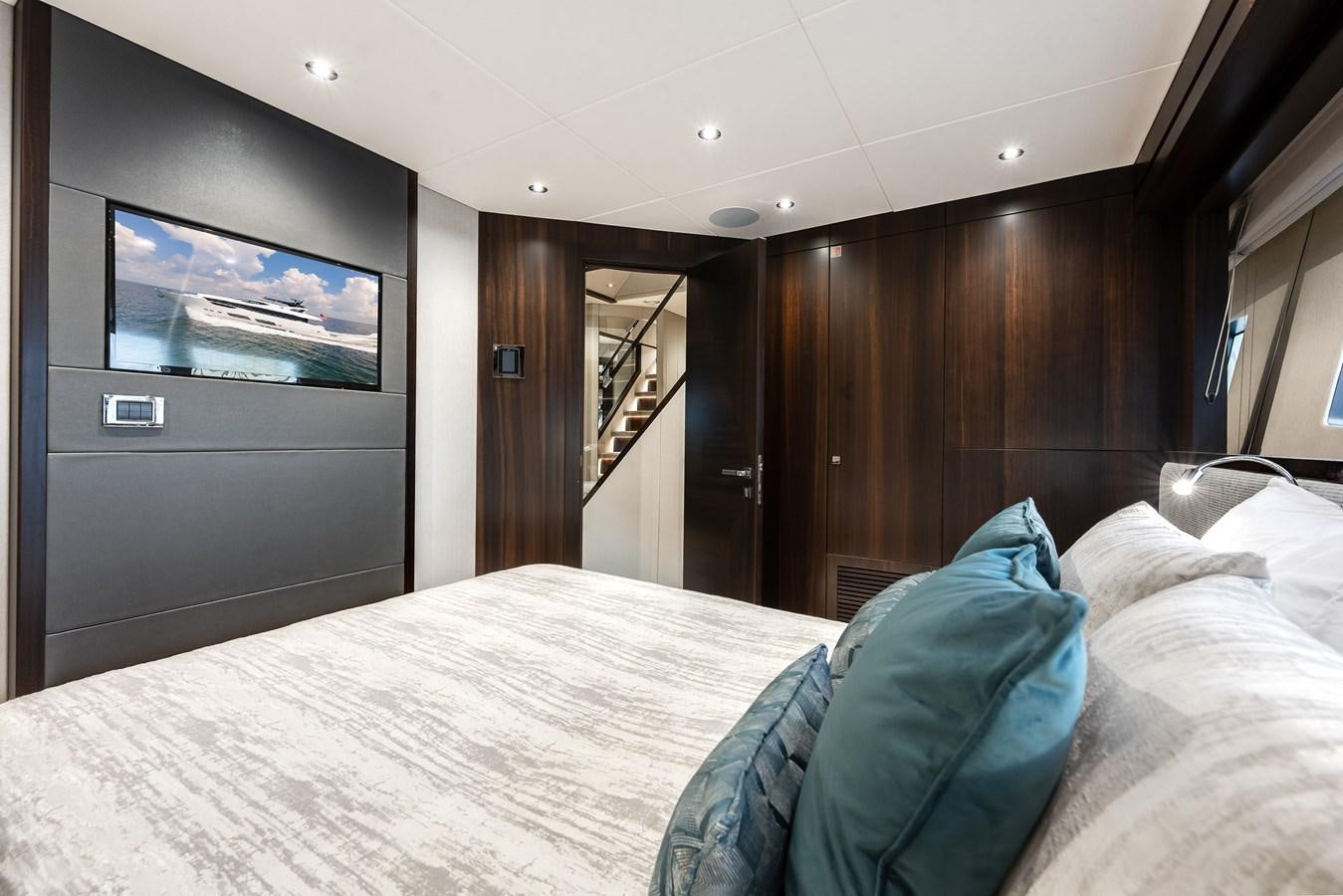 a bed with a television on the wall aboard TRIGGER HAPPY Yacht for Sale