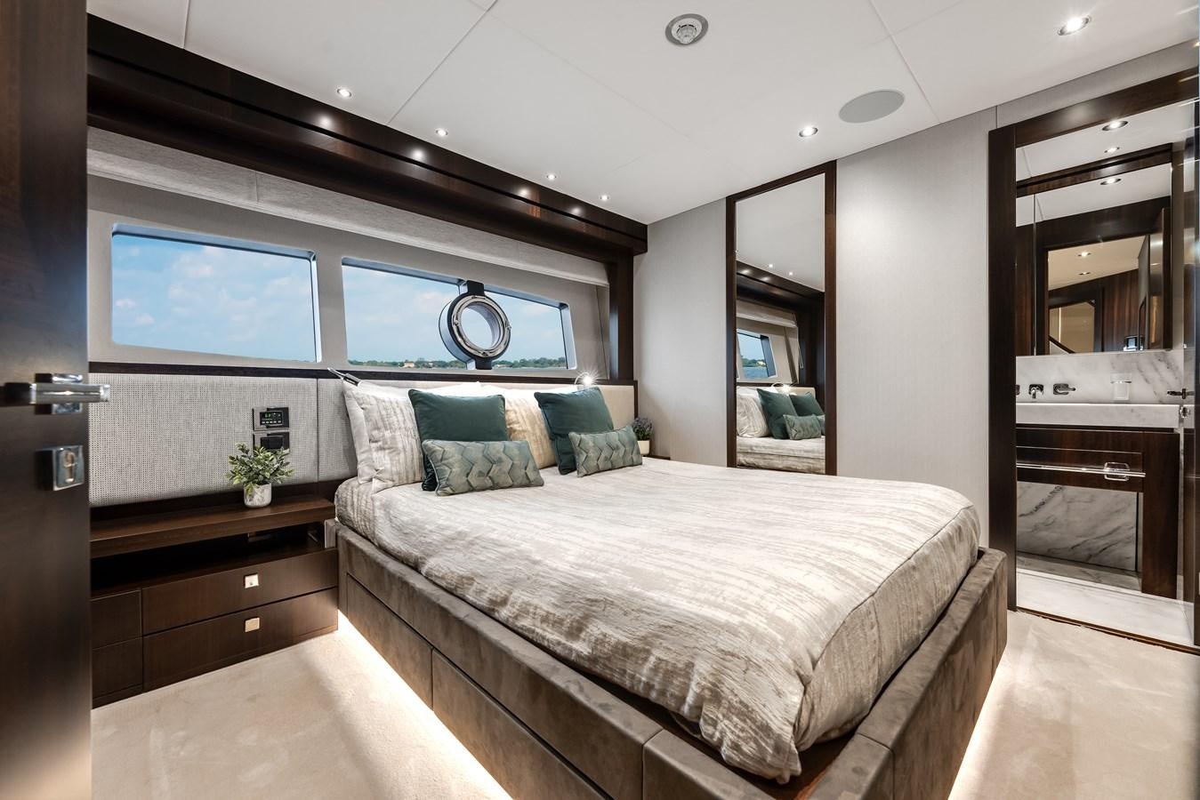 a bedroom with a bed and a mirror aboard TRIGGER HAPPY Yacht for Sale