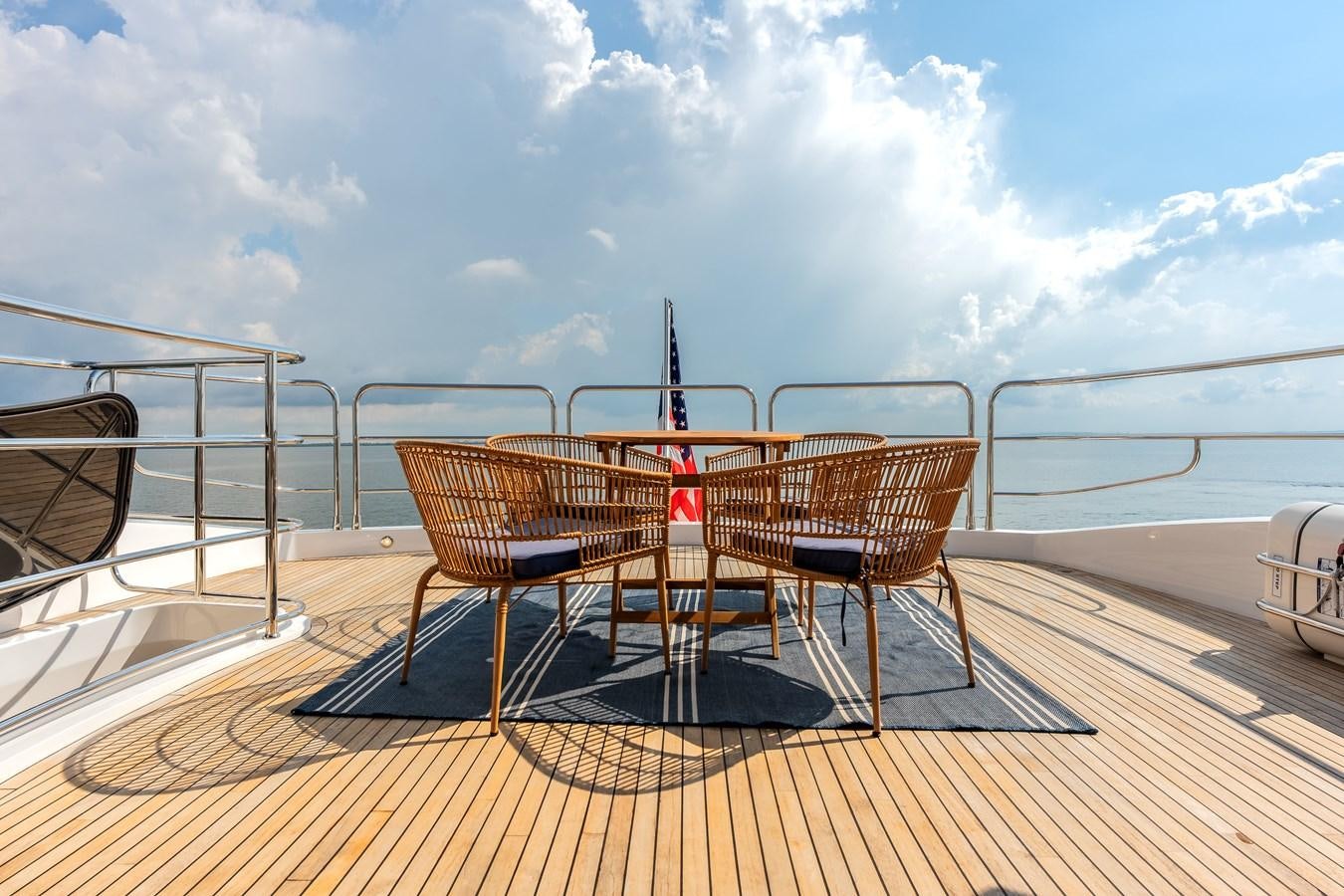 a deck with chairs and a table on it aboard TRIGGER HAPPY Yacht for Sale
