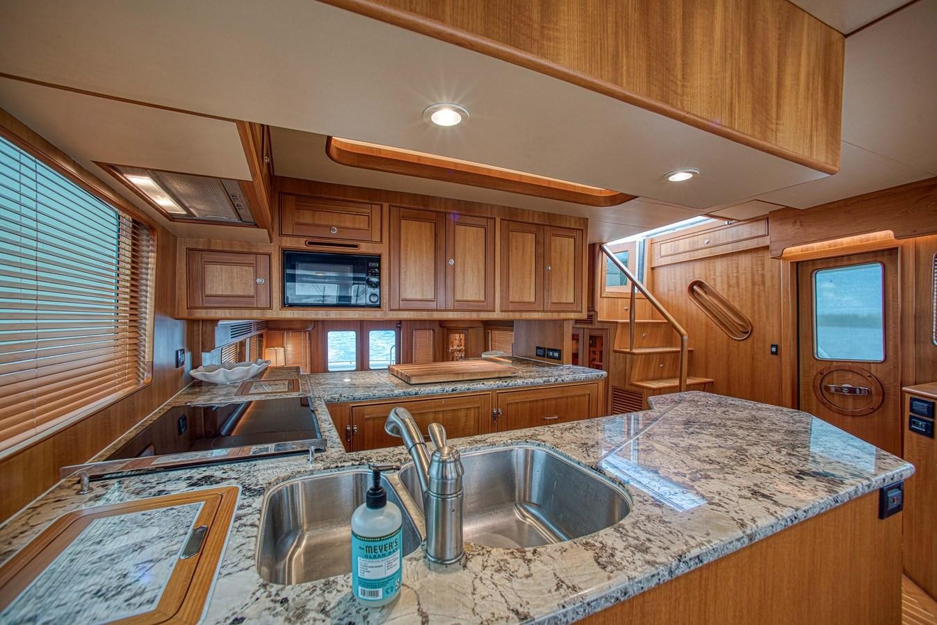 a kitchen with wooden cabinets aboard TRUE NORTH Yacht for Sale