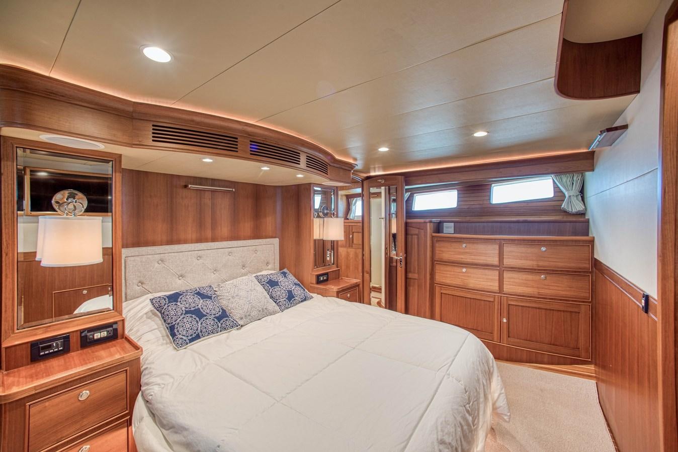 a bedroom with a bed and a dresser aboard TRUE NORTH Yacht for Sale