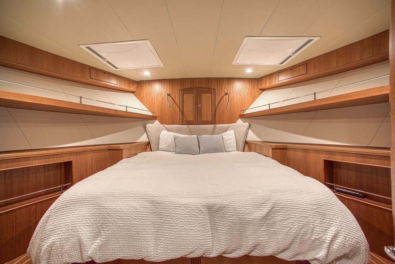 a bed with a white comforter aboard TRUE NORTH Yacht for Sale