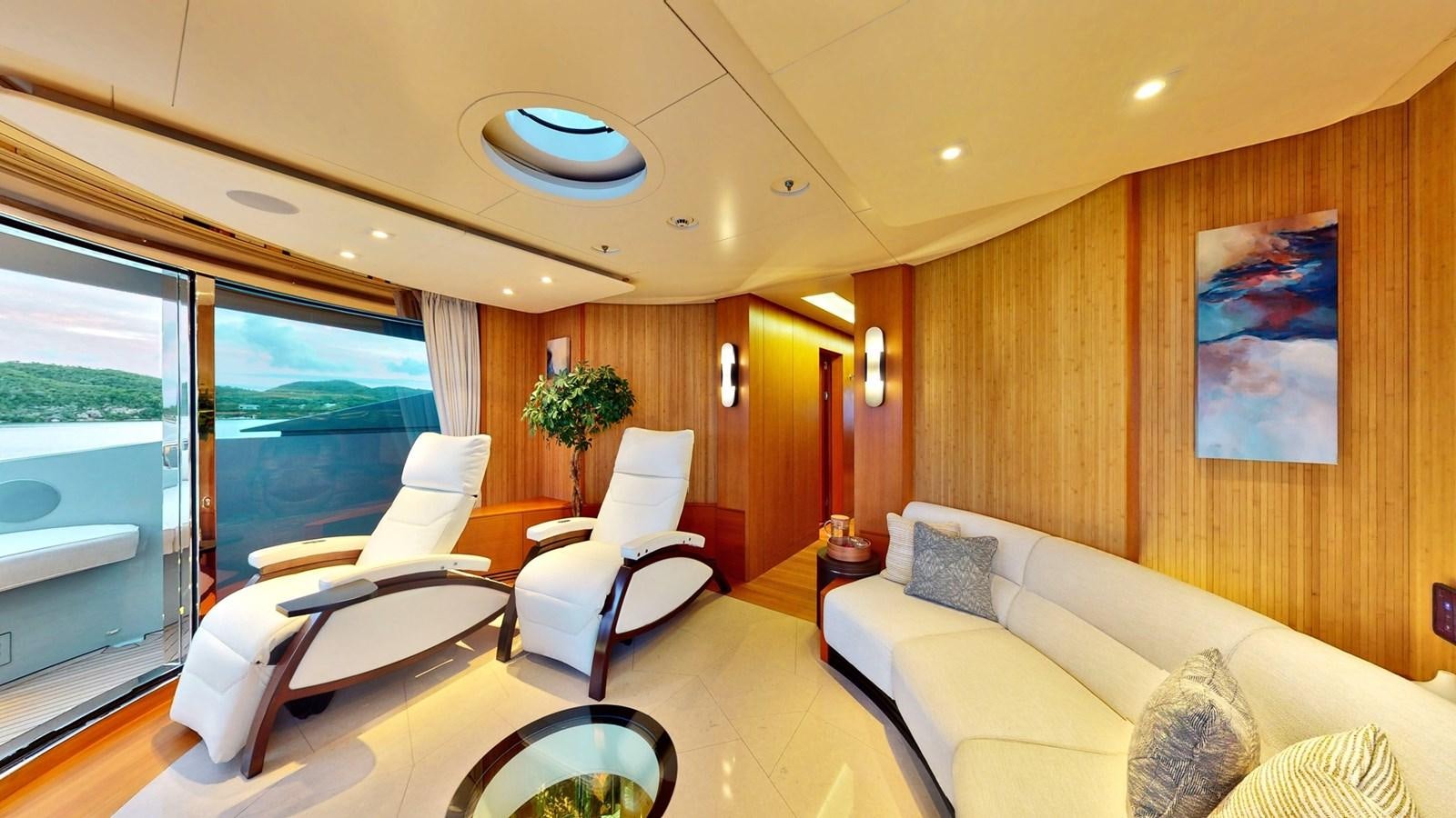 a room with a couch and a table with chairs and a large window aboard AFTER YOU Yacht for Sale