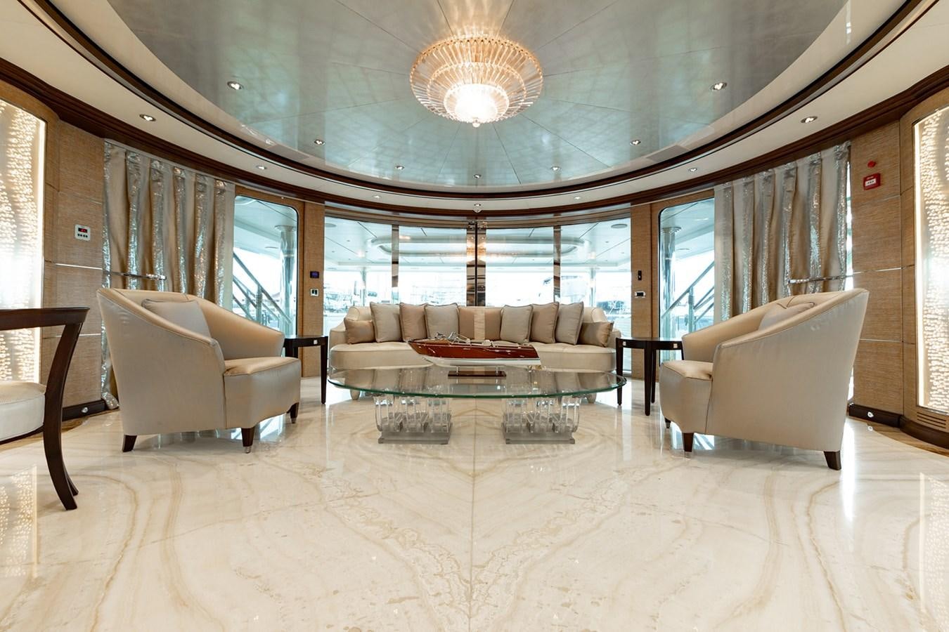 a large living room with a large chandelier aboard QUEEN MAVIA Yacht for Sale