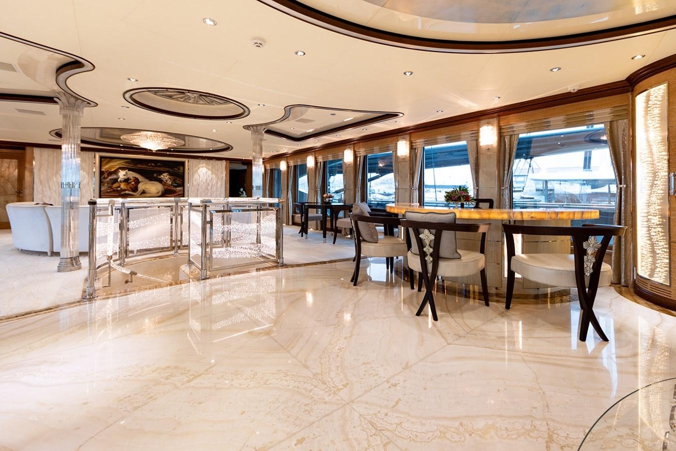a large room with a table and chairs aboard QUEEN MAVIA Yacht for Sale