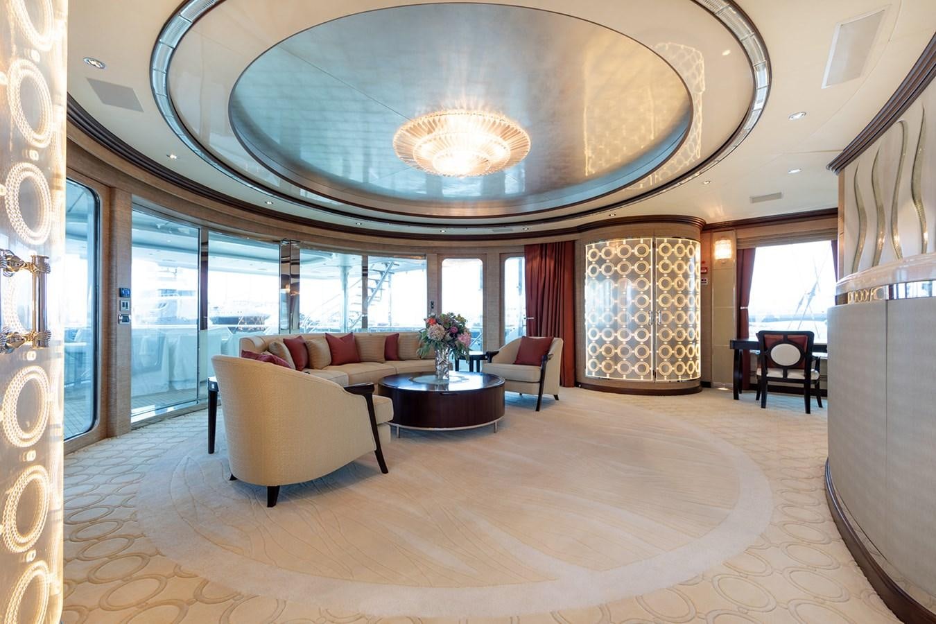 a large living room with a large chandelier aboard QUEEN MAVIA Yacht for Sale