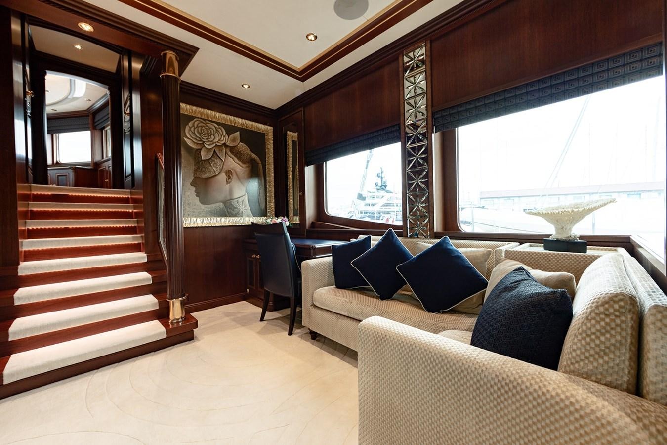 a large room with a couch and a staircase aboard QUEEN MAVIA Yacht for Sale