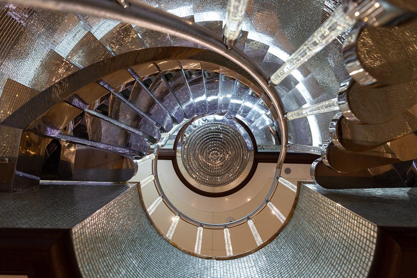 a spiral staircase with a spiral staircase aboard QUEEN MAVIA Yacht for Sale