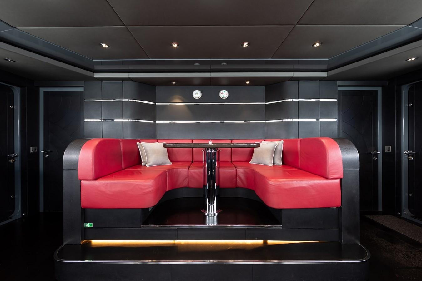 a red couch in a room aboard QUEEN MAVIA Yacht for Sale