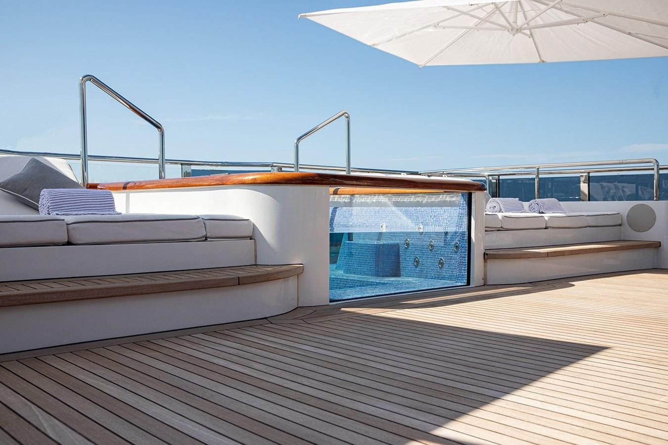 a deck with a deck and a pool aboard QUEEN MAVIA Yacht for Sale
