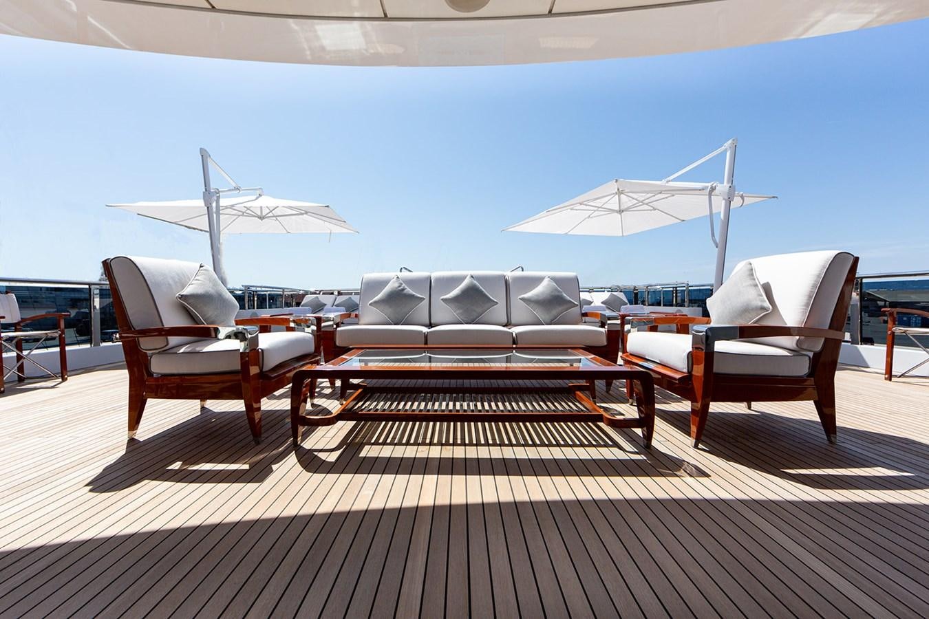 a couple of lounge chairs and a couple of umbrellas on a deck aboard QUEEN MAVIA Yacht for Sale