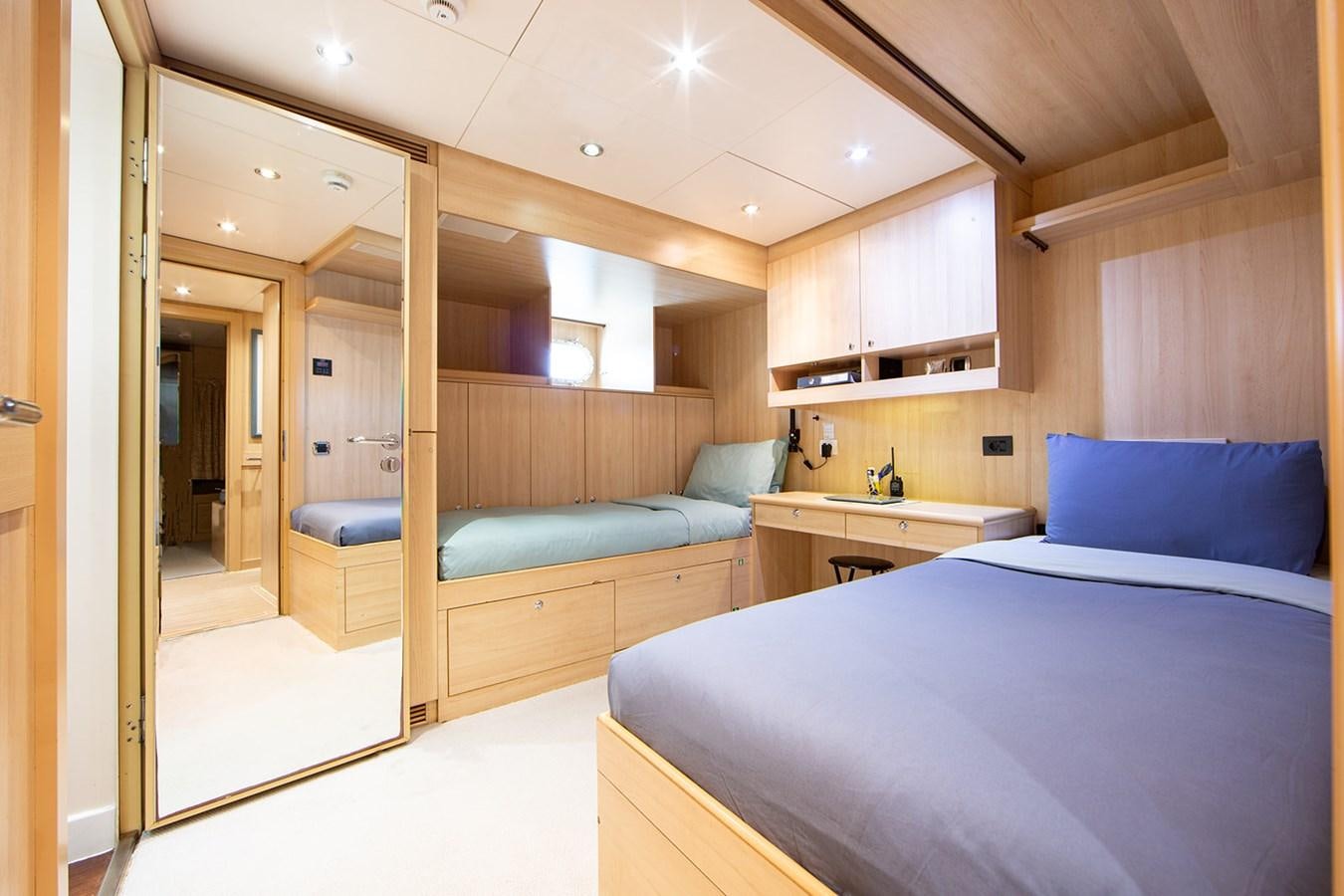 a bedroom with a bed and a desk aboard QUEEN MAVIA Yacht for Sale