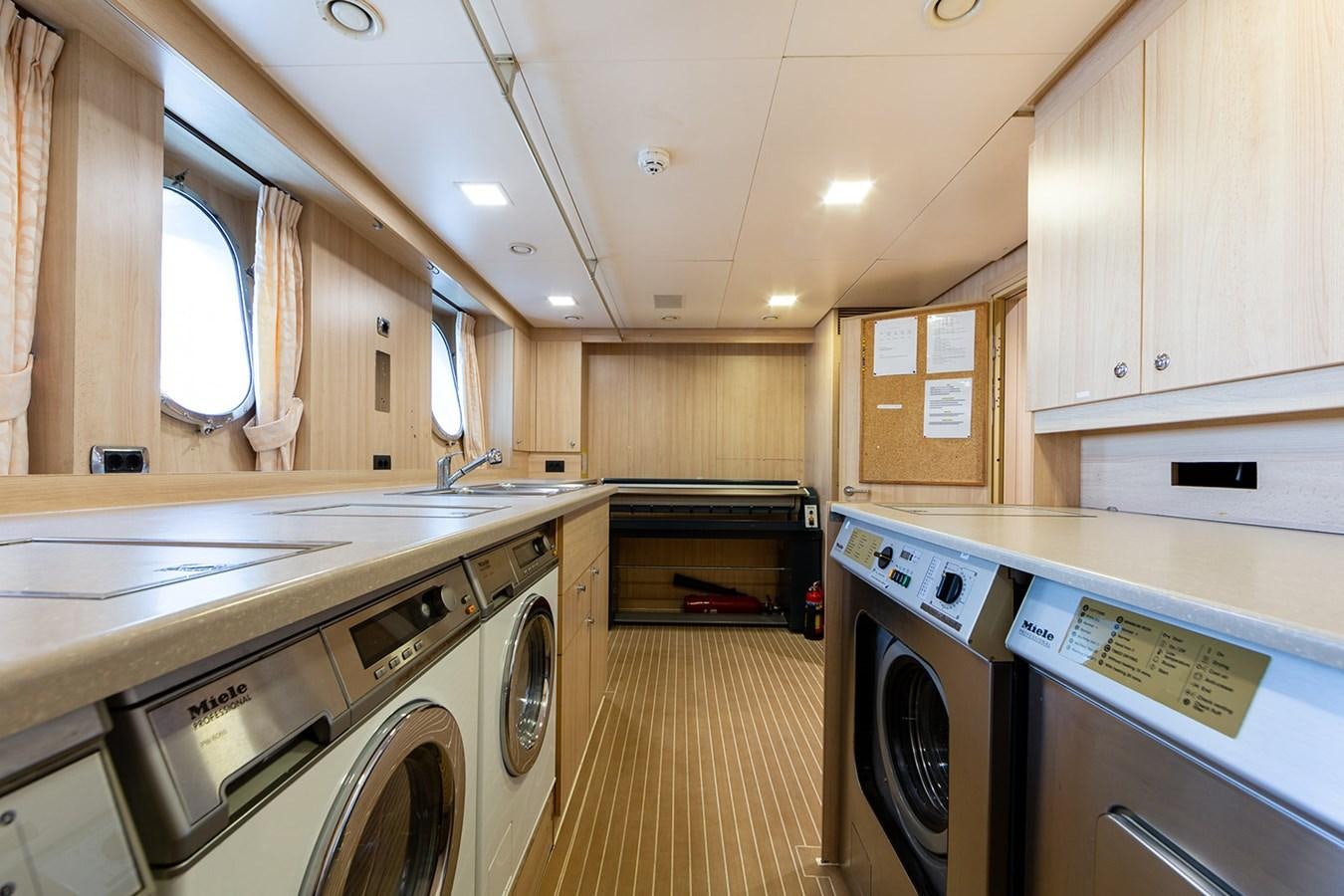 a kitchen with white appliances aboard QUEEN MAVIA Yacht for Sale