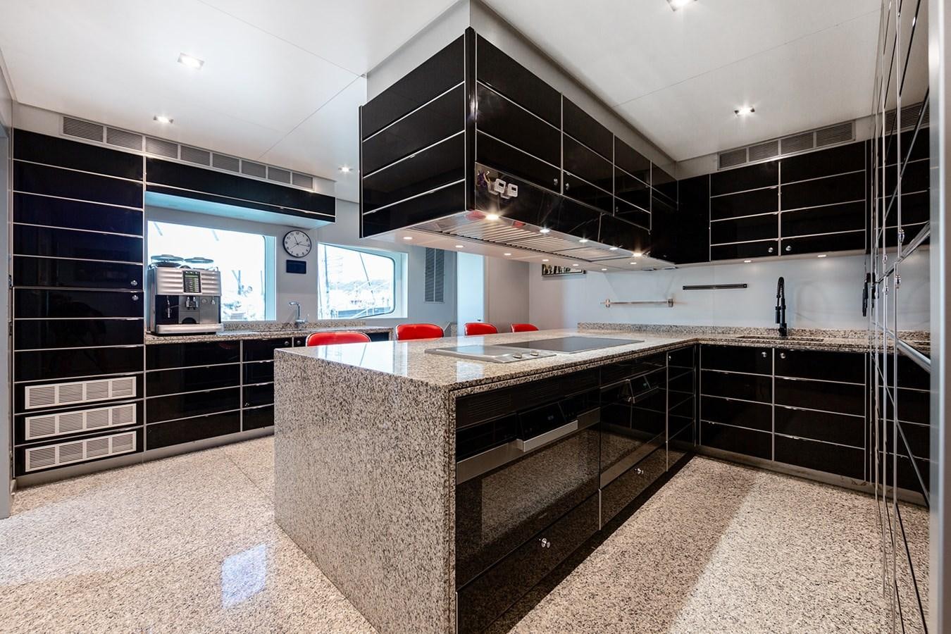 a kitchen with black cabinets aboard QUEEN MAVIA Yacht for Sale