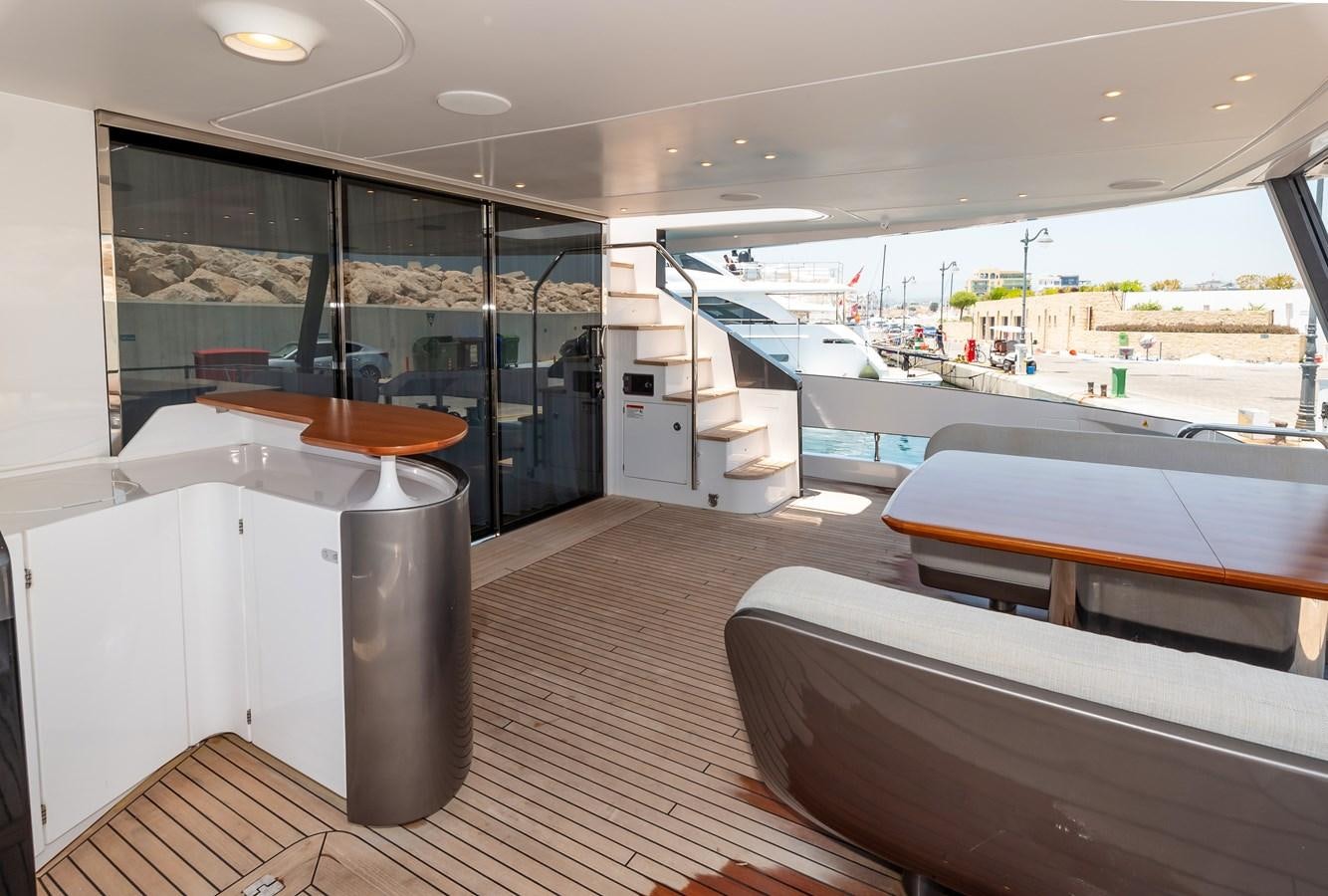 a room with a large window and a table with chairs aboard AZIMUT GRANDE 26/25 Yacht for Sale