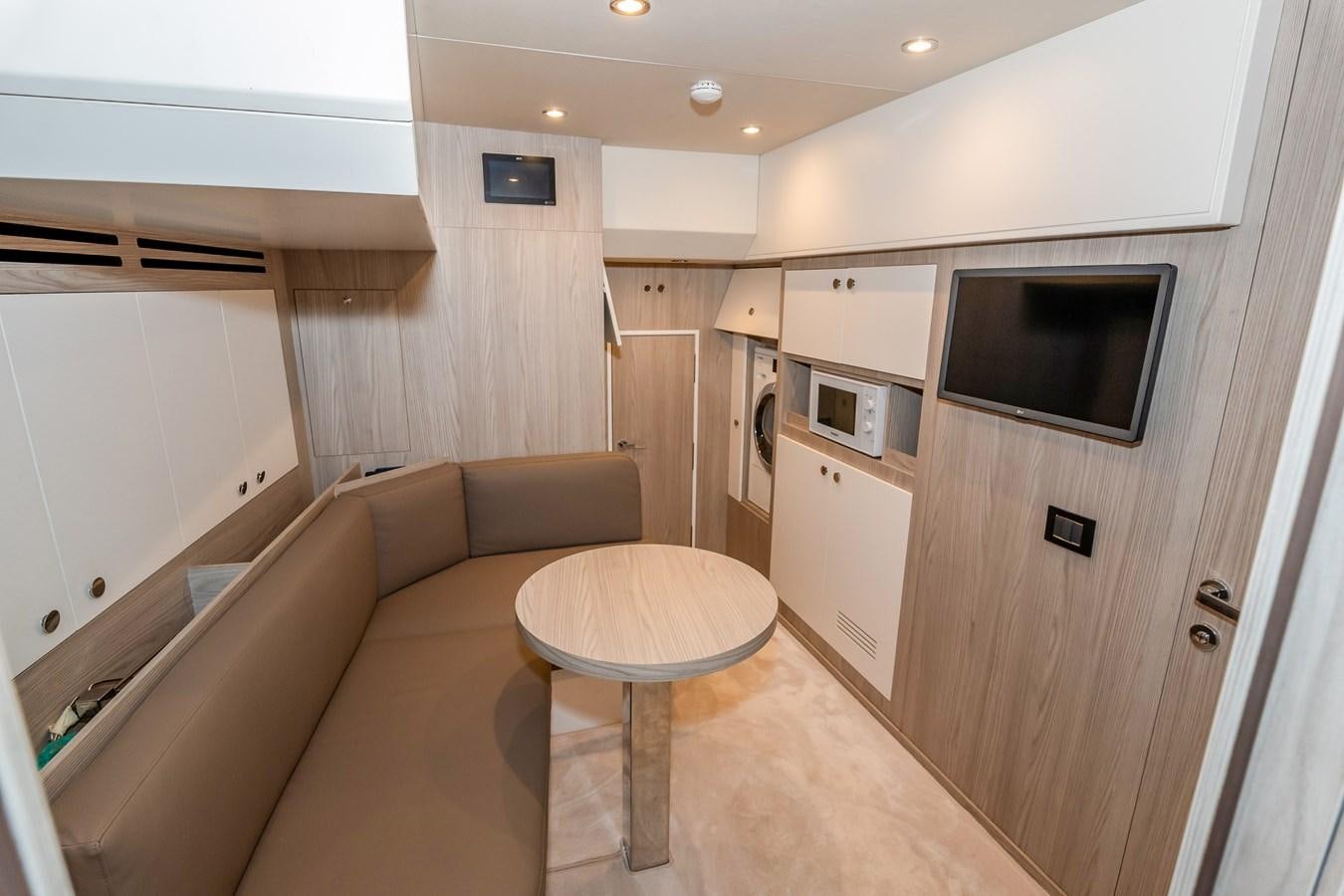 a living room with a couch and a television aboard AZIMUT GRANDE 26/25 Yacht for Sale
