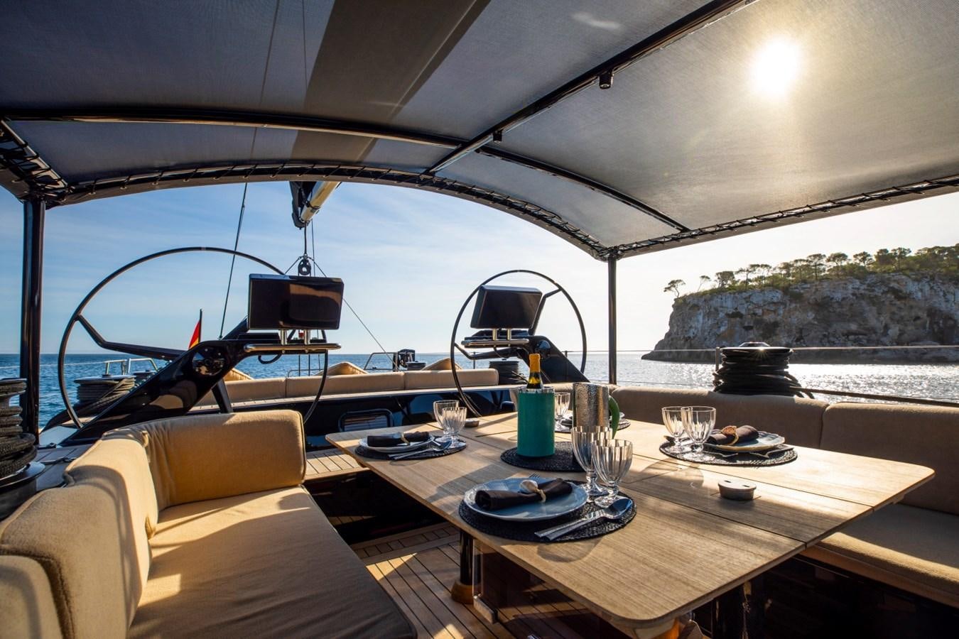 a table with a chair and a view of the water aboard GALMA Yacht for Sale