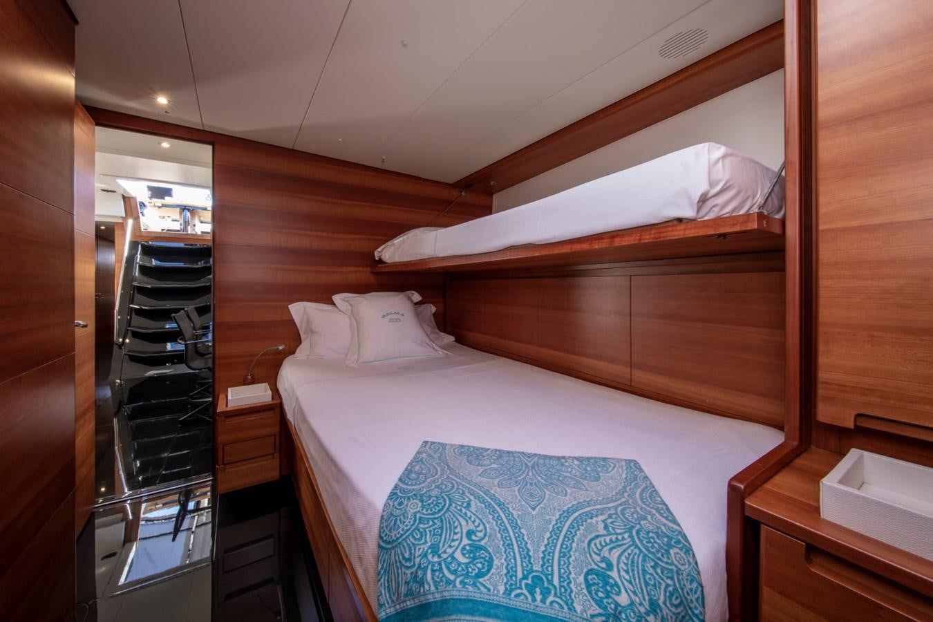 a bed with a wooden headboard aboard GALMA Yacht for Sale