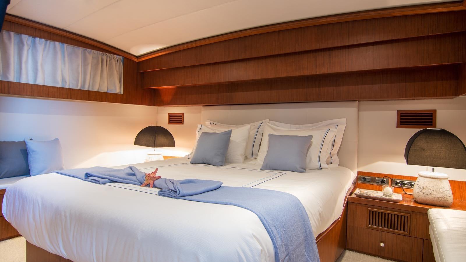 a bed with a white sheet and pillows aboard OCEANE II Yacht for Sale