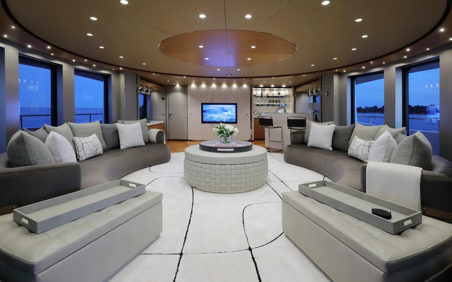 a modern living room with a large white sofa and a large window aboard MADO Yacht for Sale