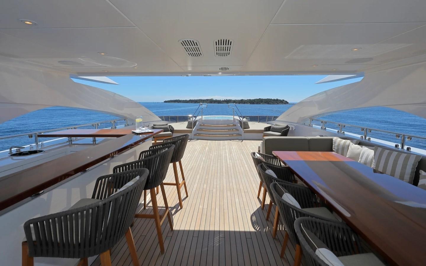 a deck with chairs and a deck overlooking the ocean aboard MADO Yacht for Sale