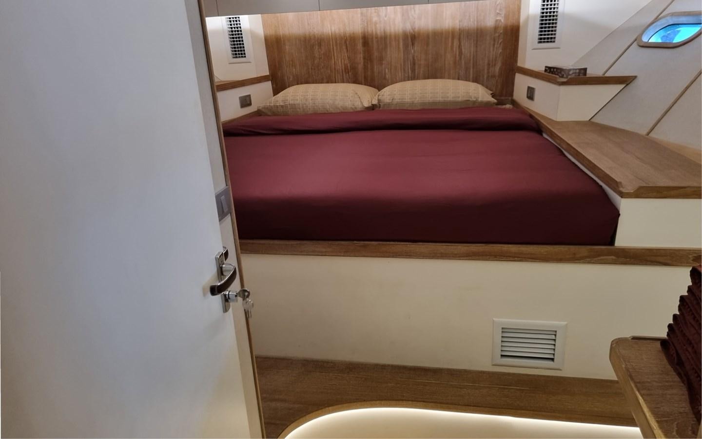 a bed with a red cover aboard ONEIRONAUT Yacht for Sale