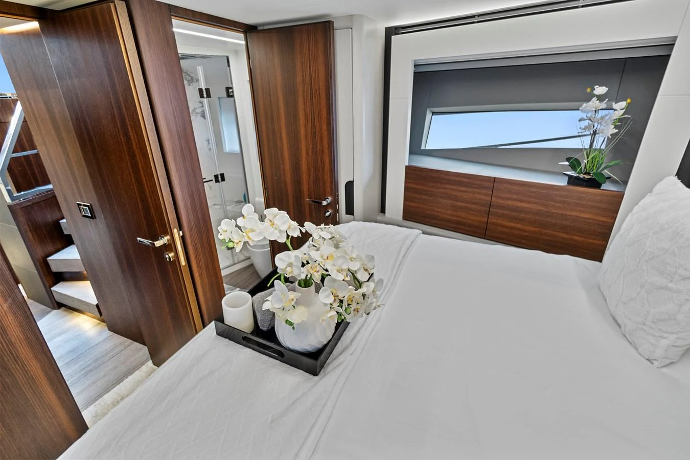 a bed with white sheets and flowers aboard SMILE Yacht for Sale