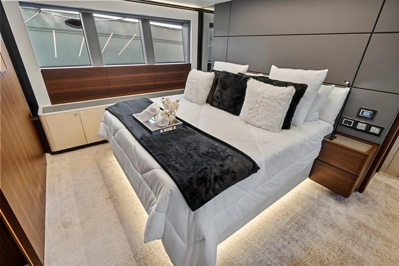 a bed with a black and white comforter and pillows aboard SMILE Yacht for Sale