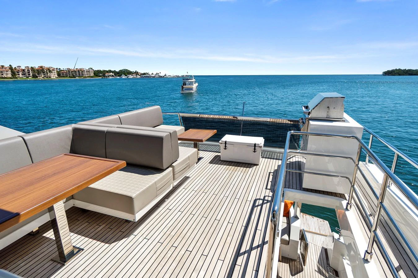 a deck with a couch and a body of water in the background aboard SMILE Yacht for Sale