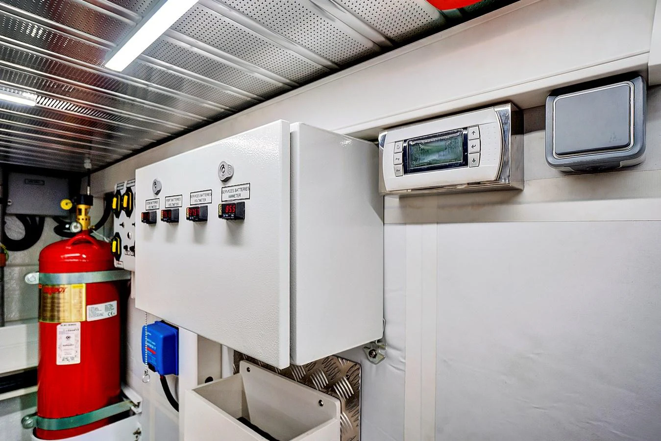 a machine with a red and yellow label and a red and white canister on a shelf with aboard SMILE Yacht for Sale