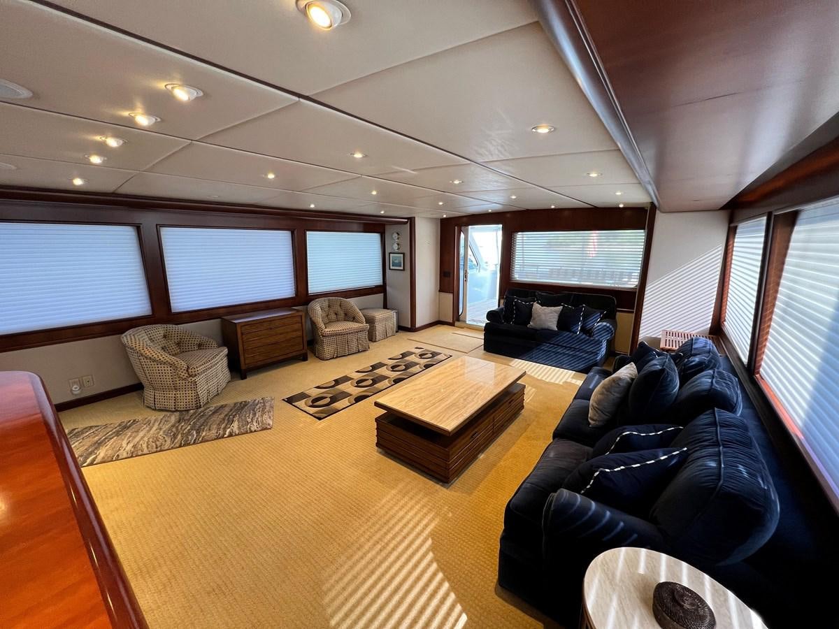 a living room with a large window aboard 2001 BROWARD RAISED PILOTHOUSE MY Yacht for Sale
