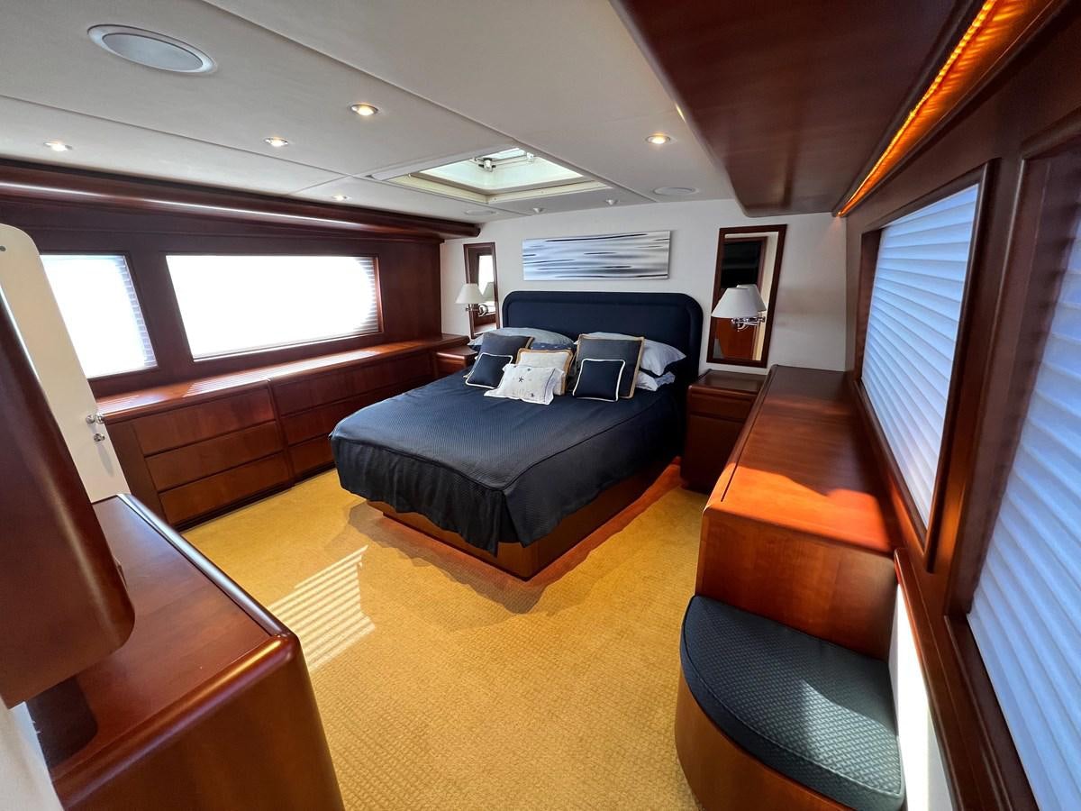 a large bedroom with a large bed aboard 2001 BROWARD RAISED PILOTHOUSE MY Yacht for Sale