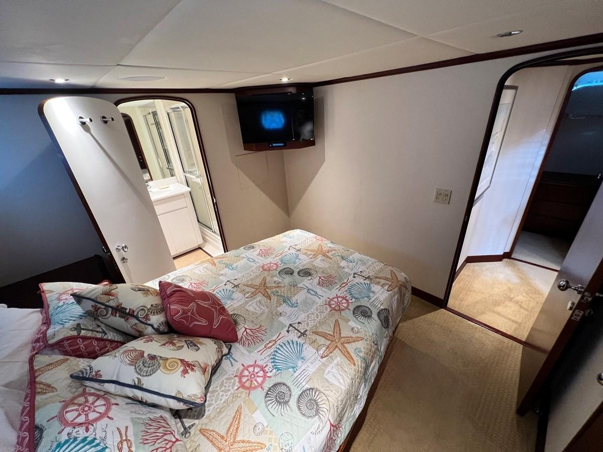 a small bedroom with a bed aboard 2001 BROWARD RAISED PILOTHOUSE MY Yacht for Sale