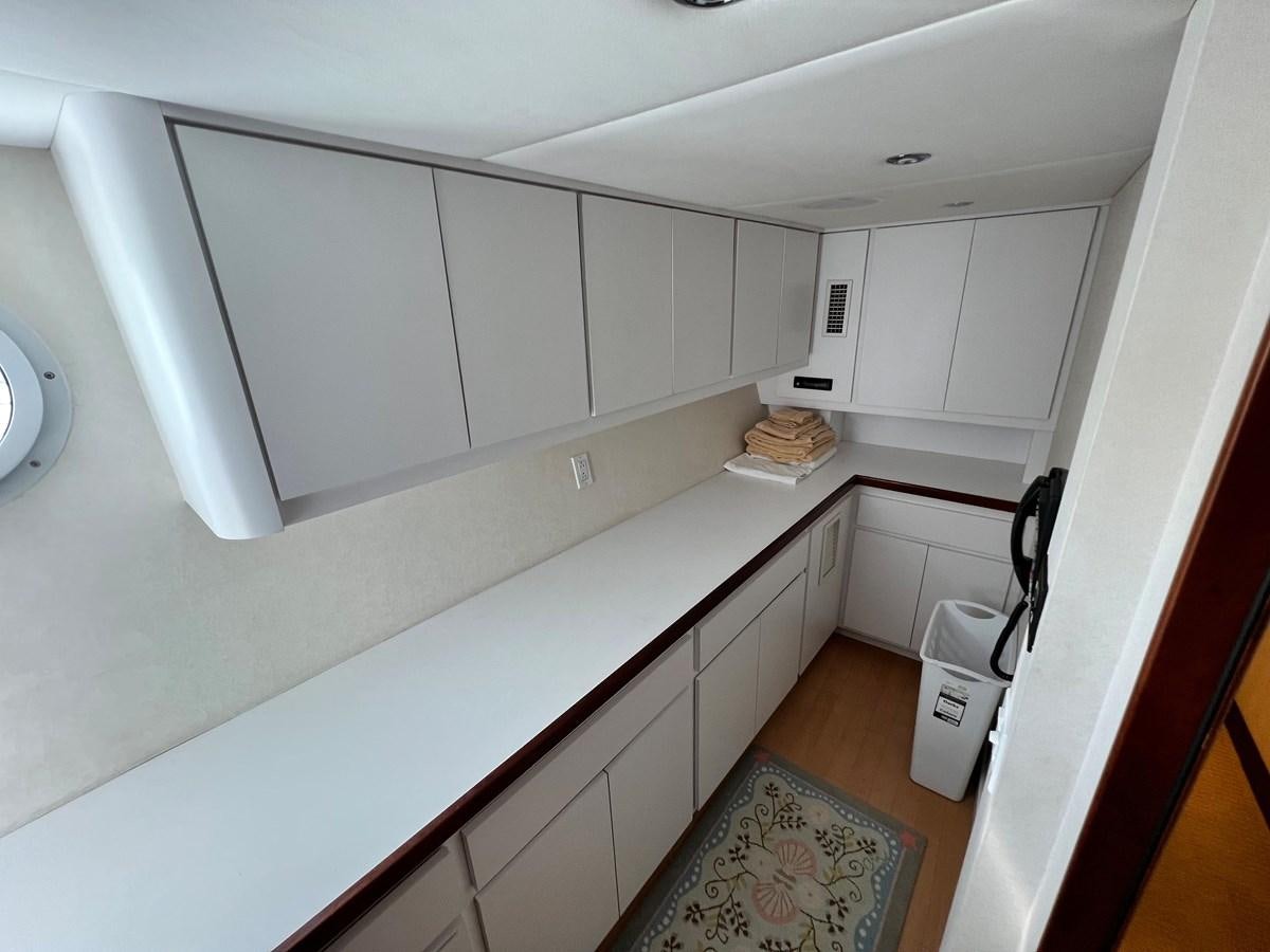 a kitchen with white cabinets aboard 2001 BROWARD RAISED PILOTHOUSE MY Yacht for Sale