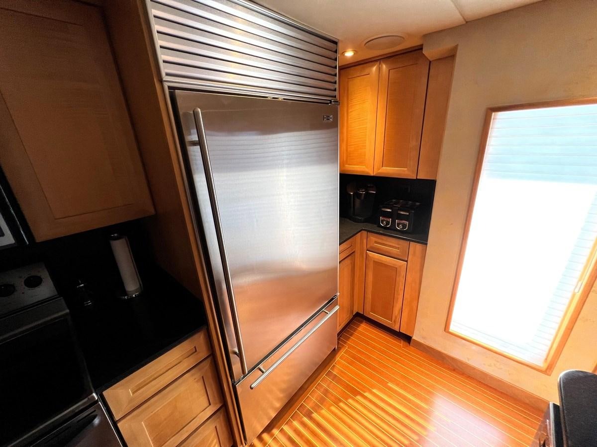 a kitchen with a stainless steel refrigerator aboard 2001 BROWARD RAISED PILOTHOUSE MY Yacht for Sale