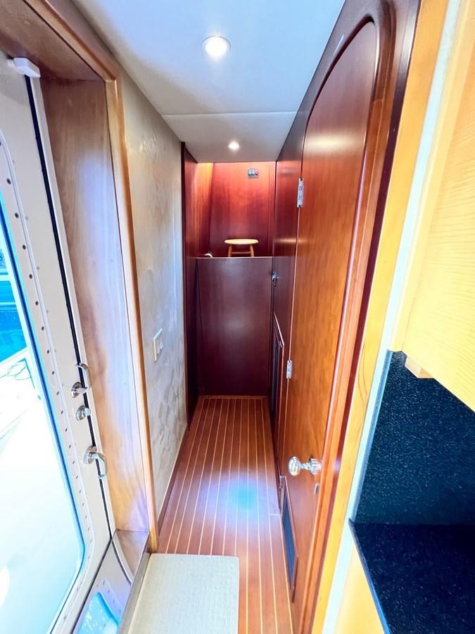 a hallway with a wood door aboard 2001 BROWARD RAISED PILOTHOUSE MY Yacht for Sale