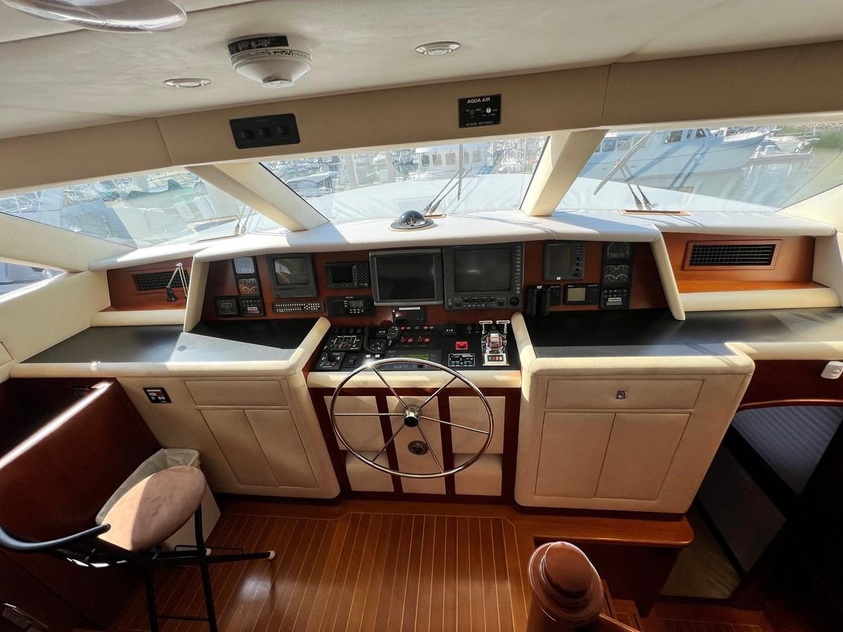 a room with a computer and other electronics on the shelves aboard 2001 BROWARD RAISED PILOTHOUSE MY Yacht for Sale
