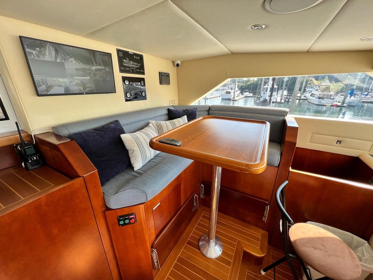 a living room with a couch and a table aboard 2001 BROWARD RAISED PILOTHOUSE MY Yacht for Sale