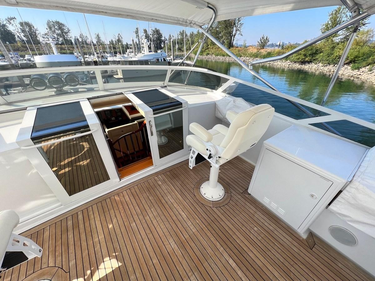 a deck with a chair and a pool aboard 2001 BROWARD RAISED PILOTHOUSE MY Yacht for Sale